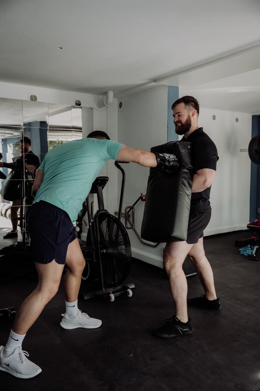 personal trainer begeleidt boksoefening tijdens training in Delft