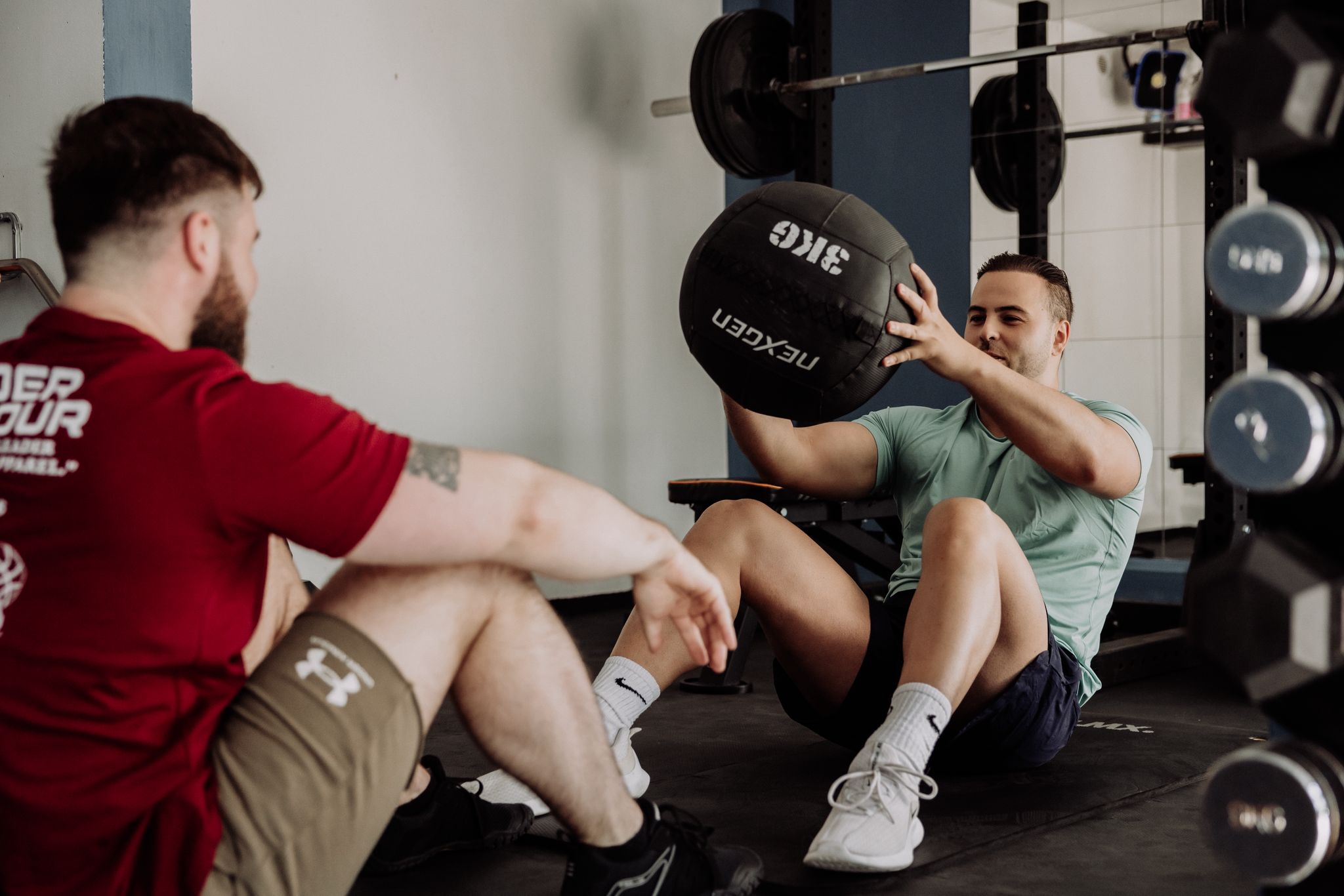 personal trainer begeleidt core oefening met medicijnbal in Delft